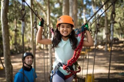 A young child taking on a sponsored zipwire challenge to raise money for Teenage Cancer Trust