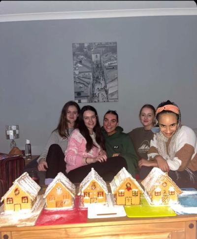 Rachel with friends and gingerbread house