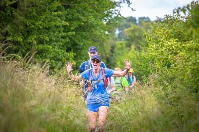 Participants run through a grassy field