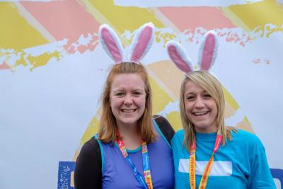 Two participants smile wearing bunny ears