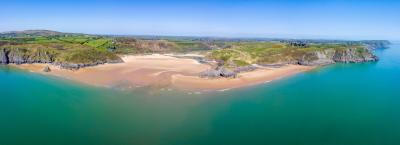 Views from above of a sandy shoreline and blue sea