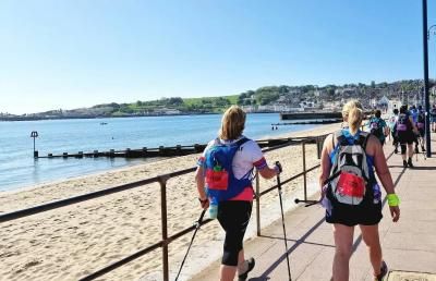 Participants walk along a beach promenade