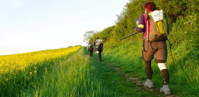 Participants trek through sunny fields