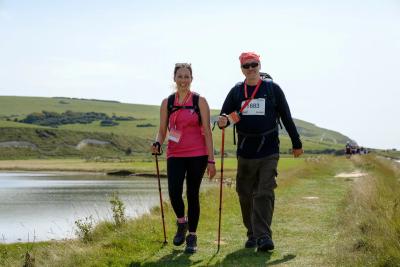 Two participants trek past a lake