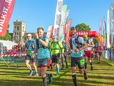 Smiling runners cross the start line at the South West Coast 50 Ultra Challenge