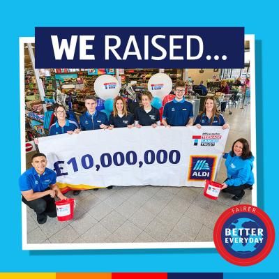 A group of Aldi colleagues hold a banner celebrating £10 million raised for Teenage Cancer Trust