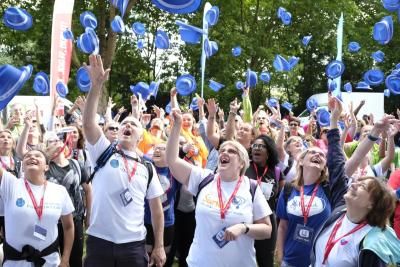 Participants throw blue hats in the air at the start line